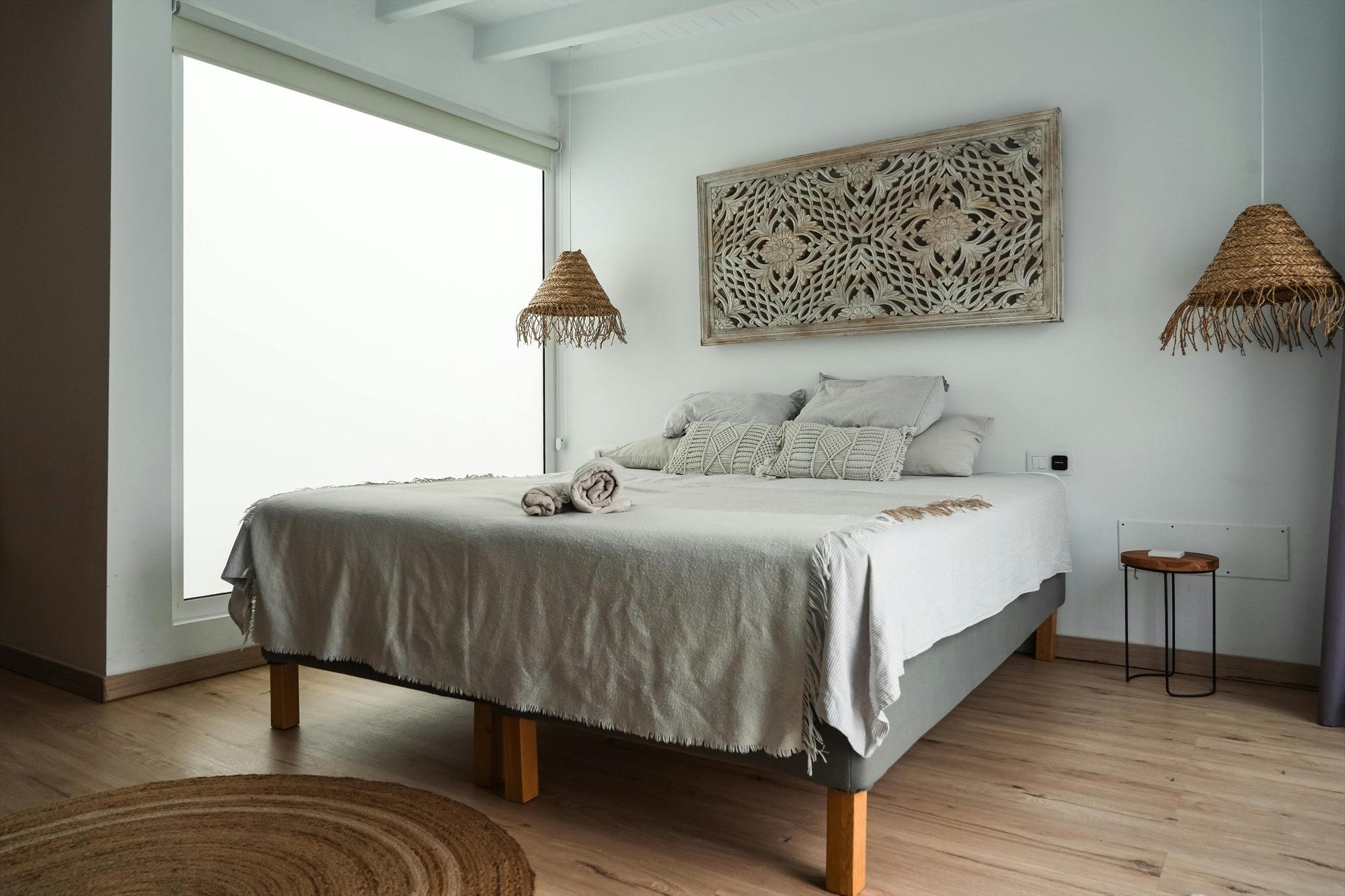 Chambre lumineuse préparée pour l'arrivée de voyageurs, linge et serviettes disposés sur le lit